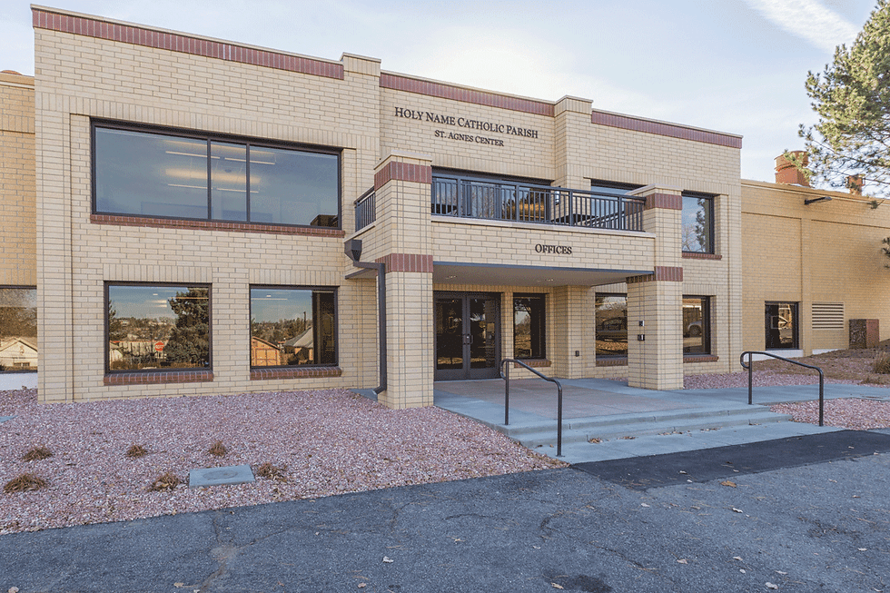 A beige brick building with red brick trim