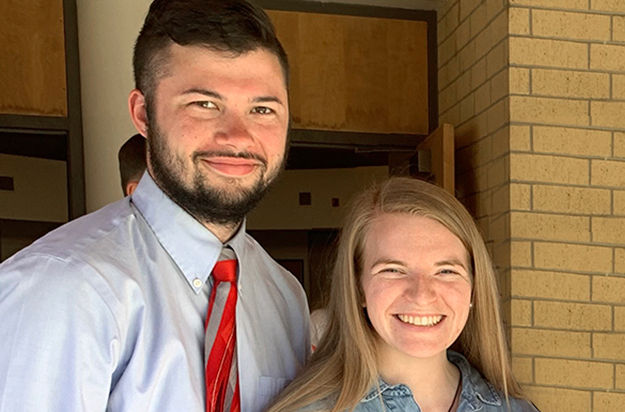 A young couple in blue smiling