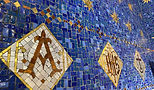 Blue mosaic tile with gold Christian symbols against it