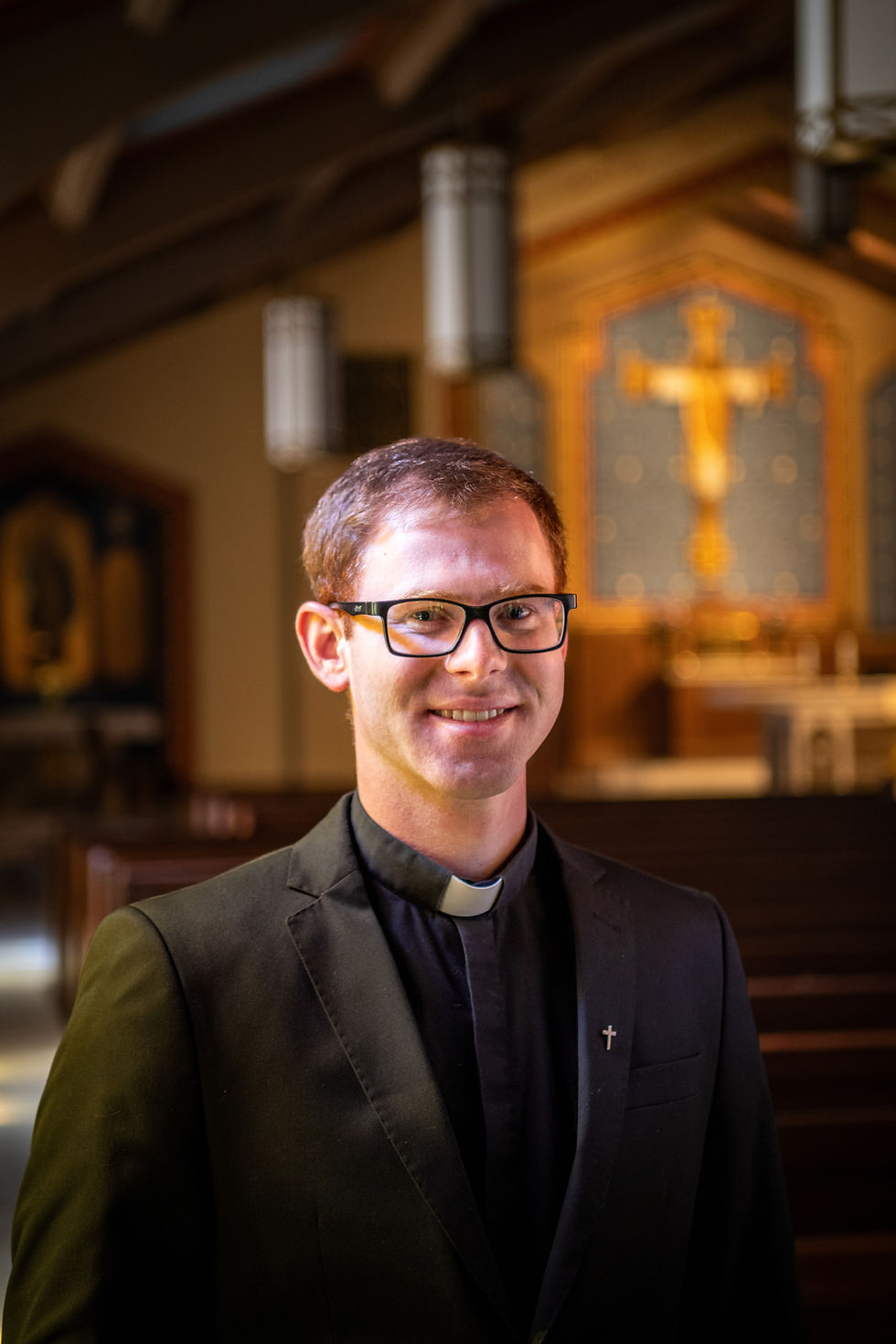 A priest in his clerics smiling while in church
